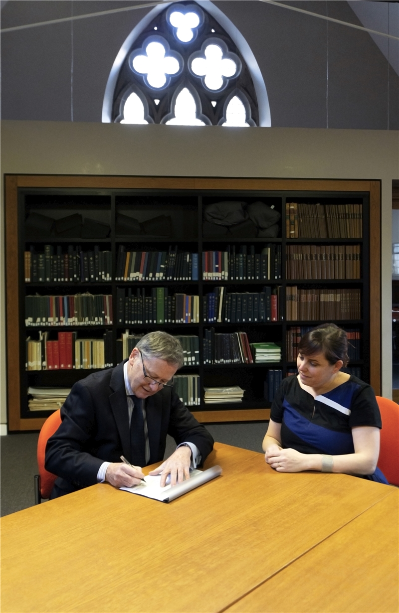  St. AU Chief Legal Officer Dr. Roy Drummond signs the TRCCS agreement (Source St. AU).