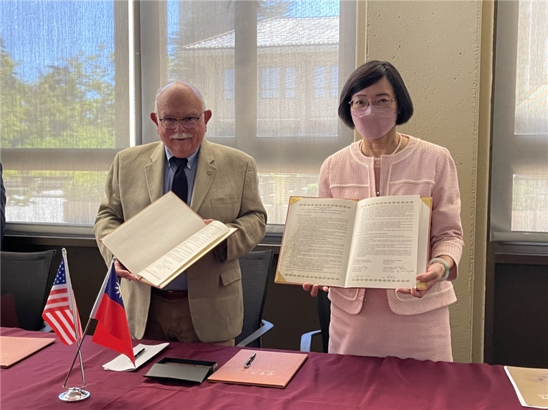 NCL Director-General Shu-hsien Tseng and Stanford Associate University Librarian Roberto Trujillo hold the signed agreements in their hands, as seen by those in attendance